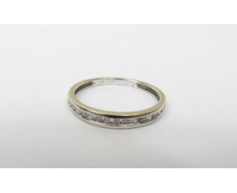 A diamond half hoop ring, the white mount stamped '18k', channel set with sixteen brilliant cuts totalling approximately 0.18