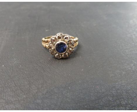 A Victorian style sapphire and rose diamond cluster ring, unmarked, the round cut stone enclosed by nine rose cuts, finger si