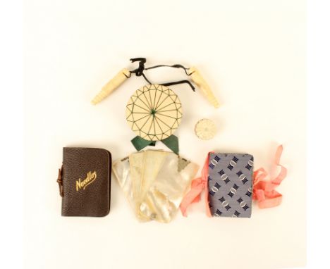 A mixed lot, comprising; a purple silk needlebook, 6.5cm, another in leather, a mother-of-pearl swivel notelet, chips to corn