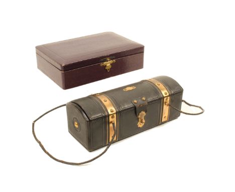 Two late 19th century leather sewing companions, comprising; a black leather dome top trunk form example with brass bindings,