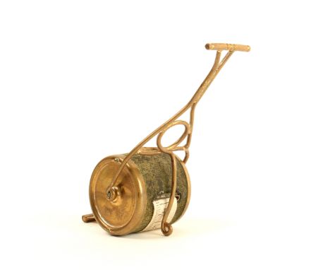 A scarce novelty brass tape measure in the form of a garden roller, baize covered roller, complete printed tape in inches and