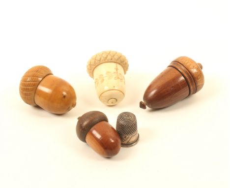 Four acorn form thimble cases, comprising; a vegetable ivory example, a bone example with carved decoration, a wooden example