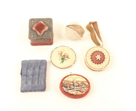 Six pincushions, comprising; an oval example with porcelain plaque 'Exhibition Edinburgh 1885', 4.5cm, a carved bone disc for