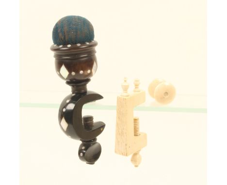 A horn sewing clamp inlaid with mother-of-pearl, the curved clamp below a vase turned pincushion inset with diamonds and dots