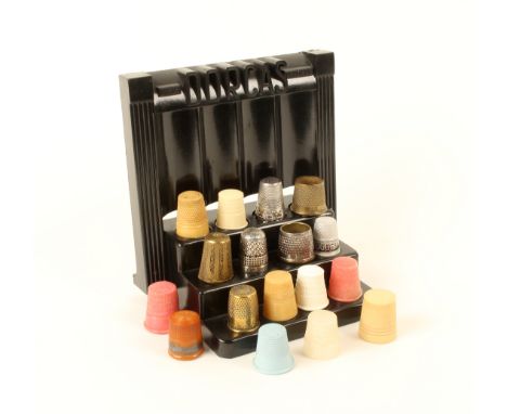 A Dorcas black plastic 'odeonesque' thimble display stand, with a selection of thimbles, including one silver example with ca