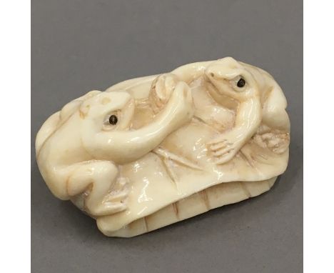 A bone netsuke in the form of frogs