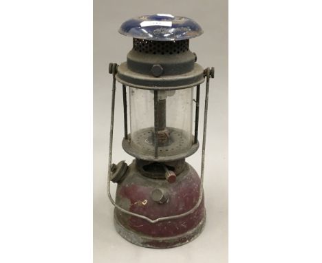 An enamel Tilley lamp and two brass Primus stoves