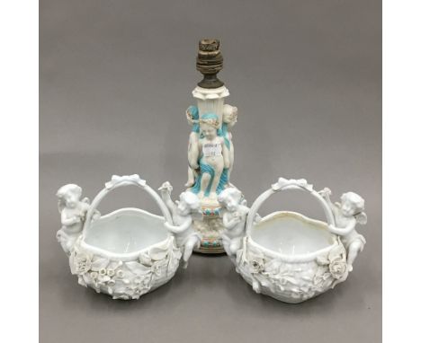 A pair of Continental porcelain baskets with applied cherubs and flowers, together with a Continental figural porcelain lamp 