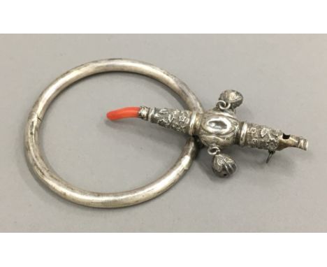 A Victorian unmarked silver child's rattle and a bangle