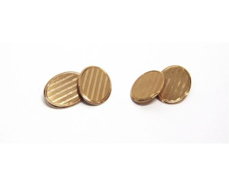 A PAIR OF EARLY 20TH CENTURY 9CT GOLD OVAL CUFFLINKS each with two oval panels with engine-turned bands and chain inter-links