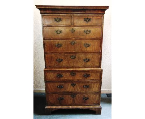 A WALNUT CHEST ON CHEST  with feather banded inlay, moulded cornice above two short and three long drawers, the base with thr