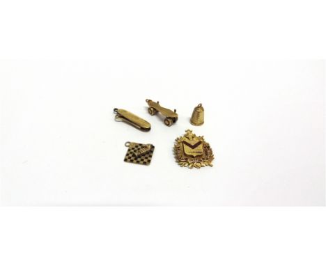 A GROUP OF FIVE EDWARDIAN AND LATER GOLD CHARMS OR PENDANTS  comprising; a button hook, stamped '9ct', 28mm long (1 ¼ in); a 