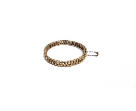 AN EARLY 20TH CENTURY GOLD HOLLOW DOUBLE-CURB LINK HINGED BANGLE On a push snap, stamped '15', approx. 8mm wide (1/3 in), 17.