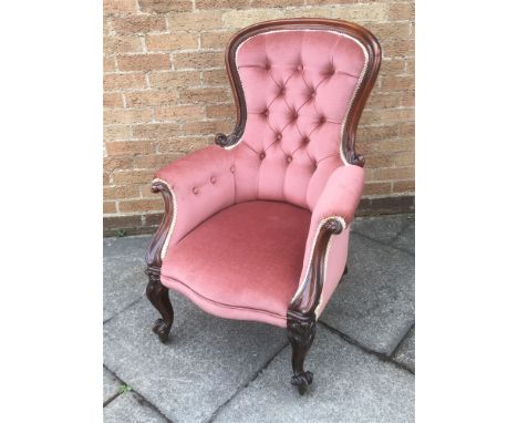 A VICTORIAN MAHOGANY ARMCHAIR  with carved mahogany frame and button upholstery on cabriole supports with brass casters