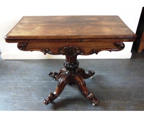 A VICTORIAN ROSEWOOD CARD TABLE  with carved decoration, on quatrefoil support, 91cm wide