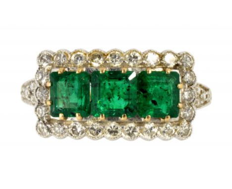 A SOUTH EAST ASIAN EMERALD AND DIAMOND RECTANGULAR CLUSTER RING, C MID 20TH C with three evenly sized step cut emeralds, in g