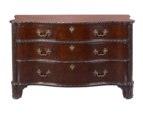 A SERPENTINE CARVED MAHOGANY COMMODE, EARLY 20TH C in George II style, fitted with three oak lined drawers with pierced brass