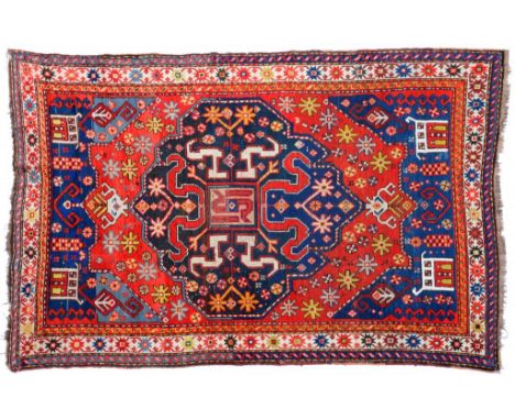 A KAZAK RUG, CAUCASUS  the madder field with polychrome guls and a central indigo medallion with 'S' shaped motifs, the indig