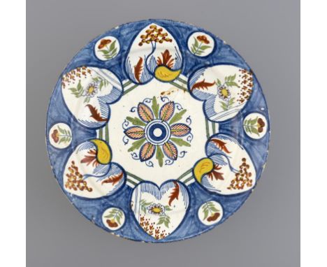 AN ENGLISH DELFTWARE DISH, BRISTOL, C1760-70 painted in red, blue, green and cadmium yellow, the six heart shaped panels on a