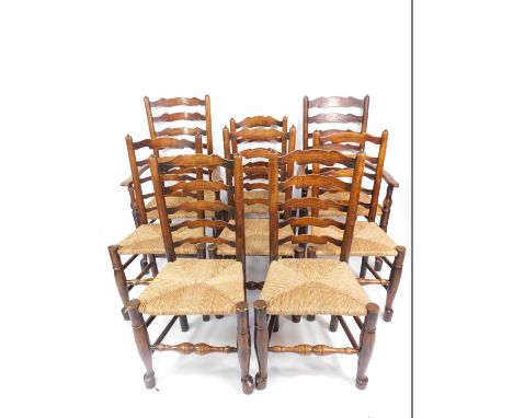 A set of eight 18thC oak ladder back dining chairs, possibly Welsh Borders, with rush seats, raised on turned legs, united by