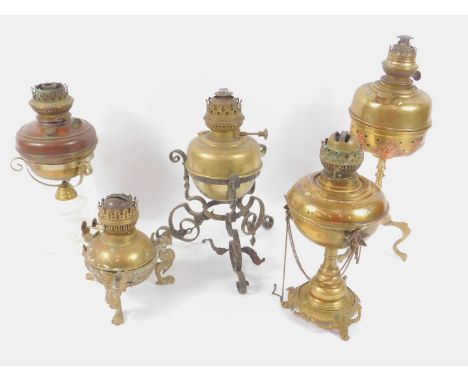 Five 19thC and later English and Continental brass oil lamps, one raised in a cast iron stand, another on a ceramic base. 