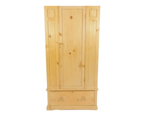 A pine wardrobe, no pediment, with single door over one long deep drawer, raised on bracket feet, 183cm H, 95cm W, 50cm D.