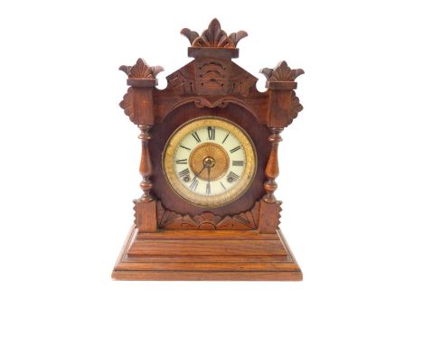 An American oak cased mantel clock, the circular brass dial with enamel chapter ring, bearing Roman numerals, eight day movem