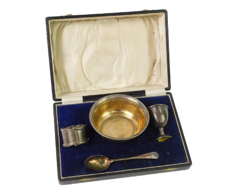 A George V silver three piece christening set, comprising bowl, egg cup and napkin ring, presentation engraved, Chester 1924,