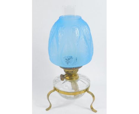 A brass framed oil lamp, with a clear glass reservoir, clear glass chimney and turquoise frosted and reserve pier glass shade