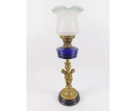 A Victorian and later brass and cut glass oil lamp, the stem cast with Putti, on a circular base, raised on a black ceramic s