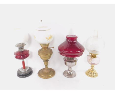 A copper oil lamp, with chimney and white glass shade printed with flowers, 63cm high, together with a brass oil lamp, with a