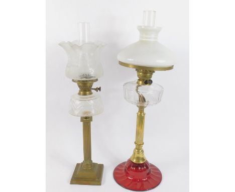 A brass and ruby glass oil lamp, with a faceted glass reservoir, chimney and white glass shade, 79cm high, together with a br