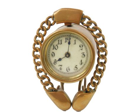 A late Victorian brass cased bedside clock, the barrel case with enamel dial bearing Arabic numerals, integral winder, set in