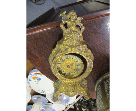 A French style brass mantle clock with a cherubic finial, and Roman numerals, 13 h, A/F