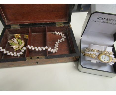 A boxed Kessaris ladies' wristwatch and matching bracelet, a costume jewellery brooch set with green stones and simulated pea