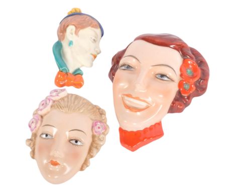 A group of 3 Vintage Art Deco ceramic wall masks, including a Czechoslovakian example with red flowers in her hair, H15cm 