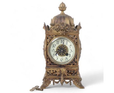 An early 20th century ornate brass mantel clock, 8-day movement with enamelled dial, top of clock has decorative scrolled myt