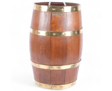An early 20th century coopered teak barrel stick stand, with polished brass bands, the applied brass plaque stating "From the