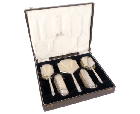 A George V engine turned Art Deco 5-piece silver-backed brush and mirror set, cased, retailed by Scott & Company 