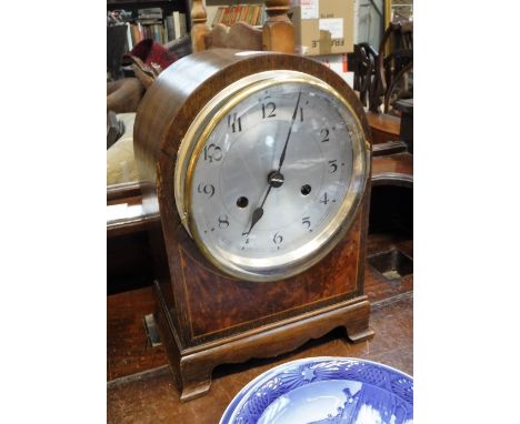 AN OAK CASED MANTEL CLOCK with a silvered dial, 12" high