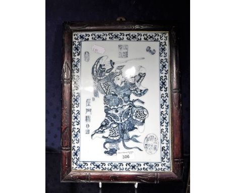 A RECTANGULAR PORCELAIN PLAQUE decorated with a Japanese warrior, within a bamboo effect surround, 10.5'' x 14'' overall