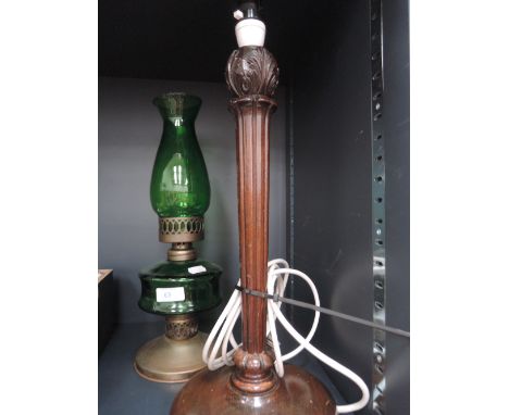 A green glass oil lamp and Treen table lamp