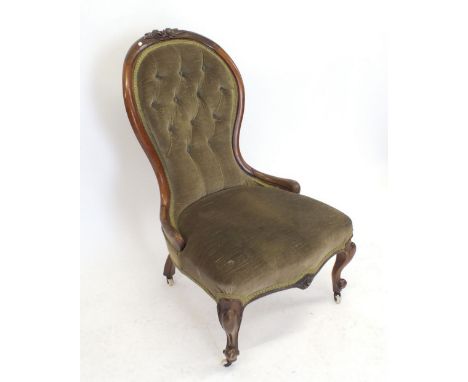 A Victorian mahogany button upholstered chair with floral carved frame 