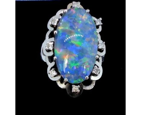 A 14 carat white gold oval opal and diamond cluster ring, size P/Q 