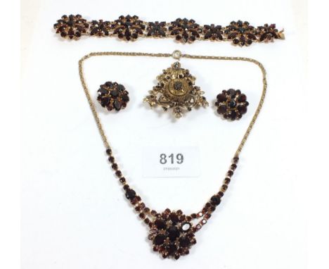 A vintage demi-parure suite of jewellery set red stones and a gilt and black brooch 