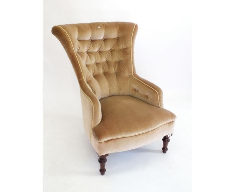 A Victorian gold button back armchair on turned feet 