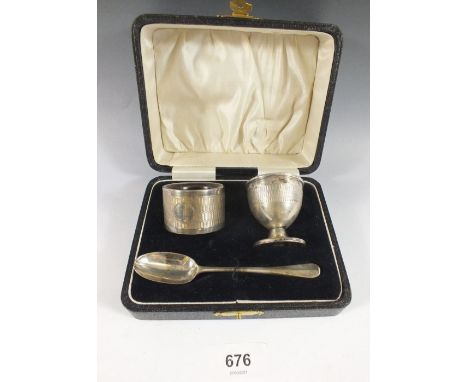 A cased three piece silver christening set including egg cup, spoon and napkin ring, Birmingham 1993 