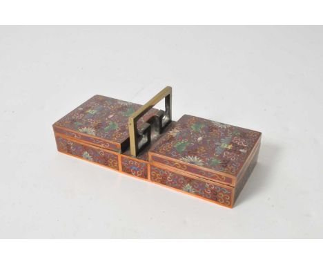 A Chinese cloisonné enamel two-divisional cigarette box, the red field decorated with polychrome symmetrical floral and folia