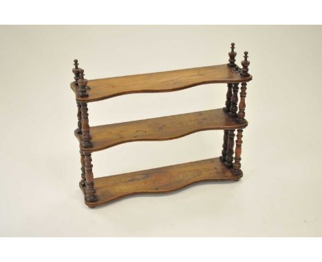 A small walnut three-tier hanging wall shelf, with turned columns and pointed finials, 76 x 20cm x 66 m high