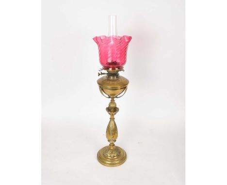A heavy Victorian brass oil lamp, with a Verity Bros, London burner, with a wrythen cranberry glass shade and clear glass chi